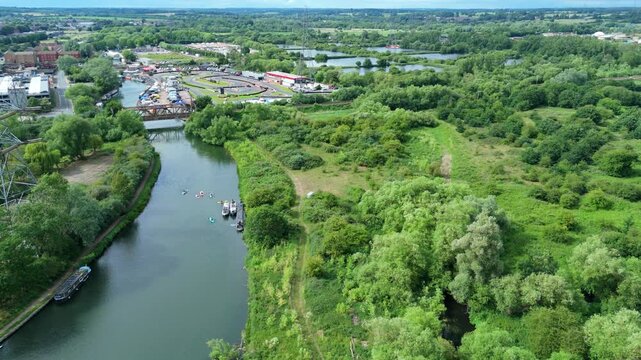Aerial view of the River Lee flowing past the Rye House Kart Raceway, surrounded by lush green woodland and fields in Hoddesdon, England, United Kingdom.