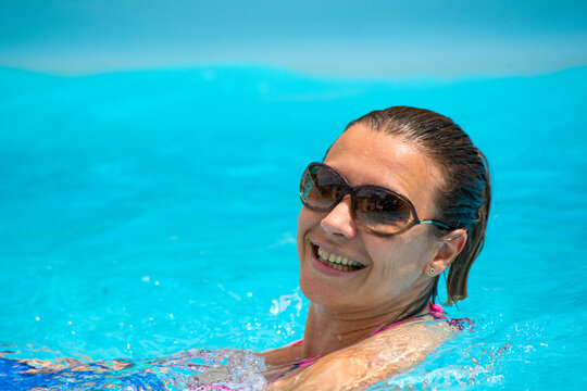 jeune femme avec des lunettes de soleil &agrave; la piscine