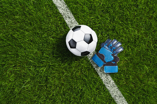 green grass texture with a soccer ball and goalkeeper gloves - well-groomed turf. Banner with copy space.