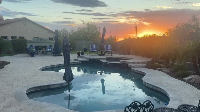 A 4k video clip of a travertine tiled pool deck in Arizona featuring an outdoor fire place, pool, spa and putting green.