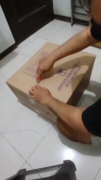 Person opening a cardboard box with a knife.