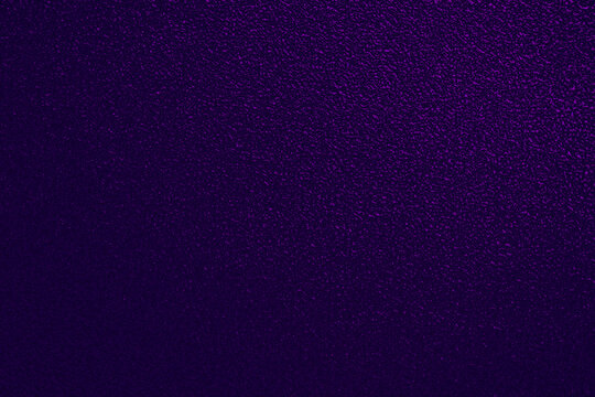 A dark purple background featuring a distinct fine-grained texture and a perceptible smooth gradient. The velvety, matte surface resembles premium textured paper, offering a rich and deep backdrop.