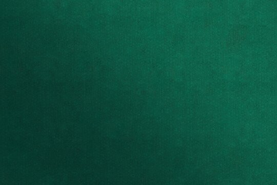 A solid deep green background featuring a fine-grained texture and a clear, perceptible smooth gradient. The matte surface mimics high-quality art paper or felt, ideal for elegant backdrops.