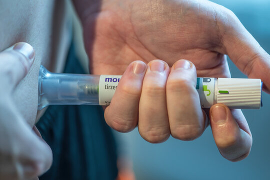 Rio de Janeiro, Brazil - June 25, 2026: Mounjaro pen injection being administered to an individual in a home setting