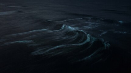 An aerial top-down view of abstract dark ocean waves swirling with bioluminescent trails at night © Dilsara