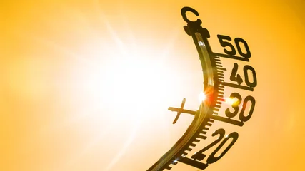 Hot weather - Heat wave / Summer heat background - Thermometer yellow orange sky and sun rays © Corri Seizinger
