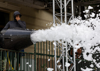 Fototapeta premium Man operates snow cannon at event