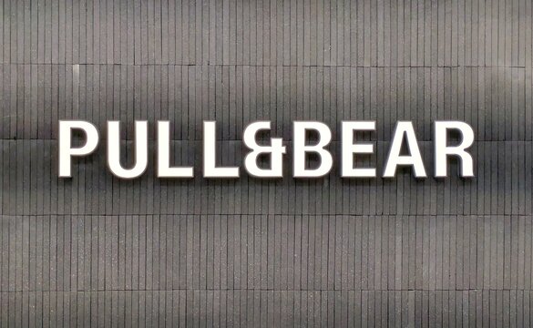 R&oacute;tulo con texto PULL & BEAR en letras 3d de color blanco sobre listones de madera, en fachada de tienda de ropa. Madrid, Espa&ntilde;a 