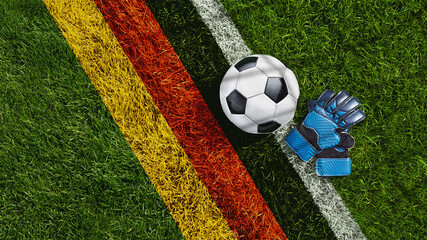 Obraz premium green grass texture with a soccer ball and goalkeeper gloves with the German flag - well-groomed turf. Banner with copy space.
