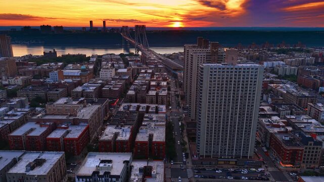 Going down over the highway in Trans-Manhattan Expressway. View on the George Washington Bridge against bright orange sky at sunset.
