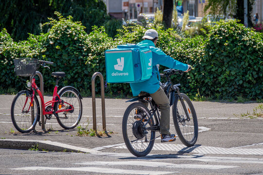 Strasbourg, France - 14 juin 2026: Livreur &agrave; v&eacute;lo de Deliveroo circulant dans une rue. Deliveroo est une entreprise britannique sp&eacute;cialis&eacute;e dans la commande et la livraison de plats cuisin&eacute;s