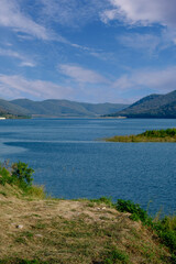 Obraz premium Vertical Scenic Mountain Landscape Overlooking Vast Blue Lake Water Reservoir