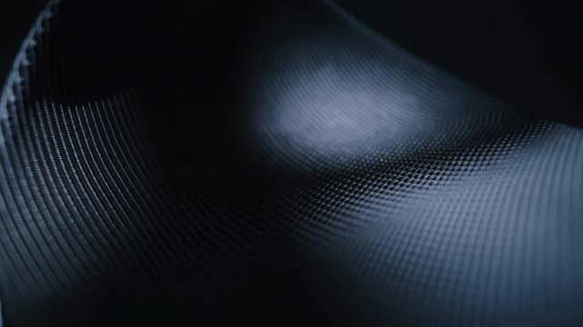 Dark technical mesh wave unfolding across wide view with cool highlights and diagonal motion, revealing dense square grid texture, smooth curves, and shifting specular glow
