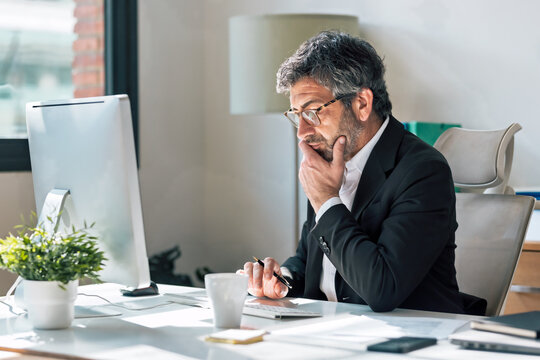 Concentrated elegant businessman working on a computer in the office