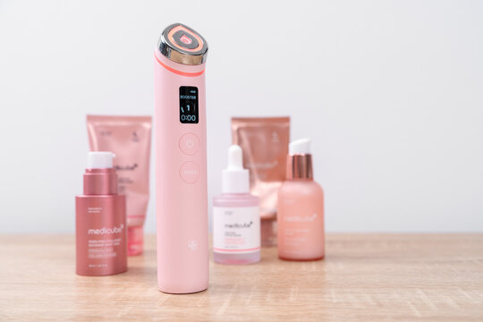 Bar, Montenegro: February 6, 2026: Pink facial beauty device Medicub Booster pro surrounded by pink skincare cosmetic product on a wooden surface in the shop window, luxury skincare routine concept