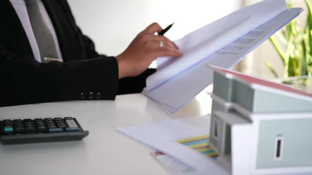 staff is explaining the information about the house lease contract documents to the buyer, the buyer signs the house lease agreement acknowledgment contract with the staff to transfer the ownership
