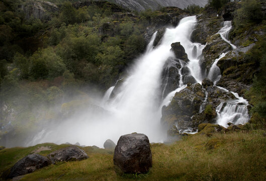Briksdal waterfall  col - the famous travel destination in Norway with the amazing waterfall and an interesting rock in the foreground