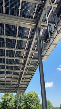 Factory hall with solar panels on roof, renewable energy for industrial production  with blue Sky vertical 4k