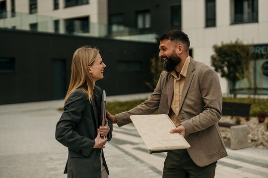 Business colleagues networking and discussing outdoors in urban setting