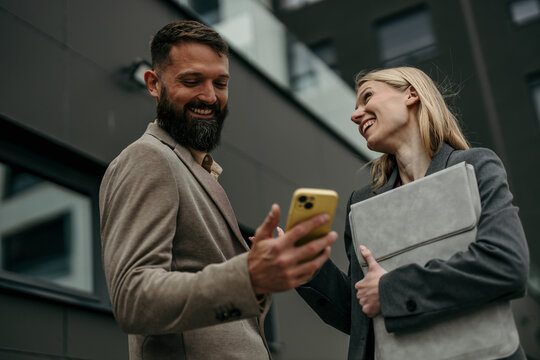 Business partners sharing online content on smartphone