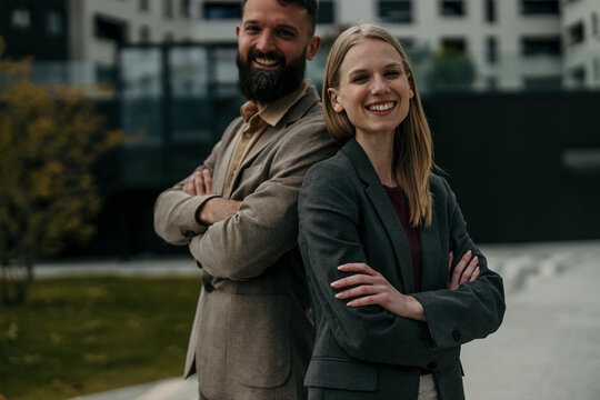 Diverse business professionals standing back to back smiling