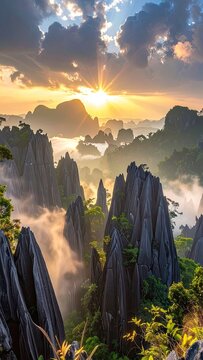 Dramatic sunrise illuminates a mystical landscape of jagged karst mountains shrouded in mist.