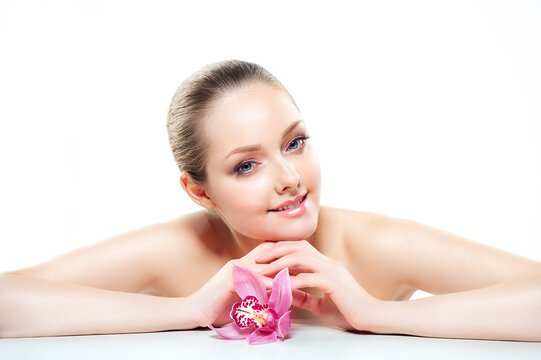 Beautiful Young Woman with Clean Fresh Skin touch own face . Facial treatment . Cosmetology , beauty and spa .
