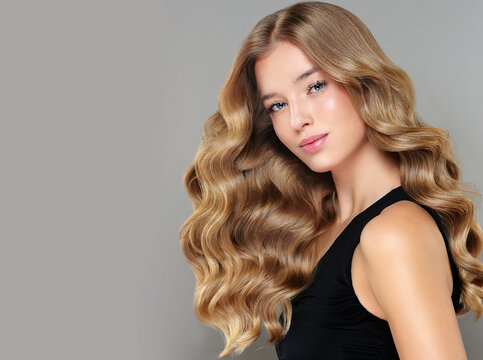 Beauty blonde girl with long and shiny wavy Hair ,coloring and toning, shatush and balayash . Beautiful woman model with curly hairstyle 