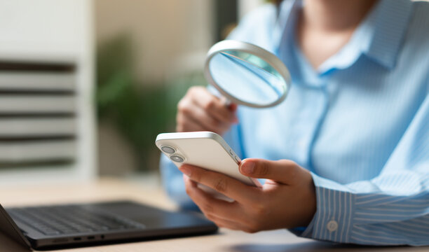 Mobile fraud detection and digital security concept with smartphone and magnifying glass. Online verification, cyber risk assessment, identity protection, data privacy and cybersecurity investigation.
