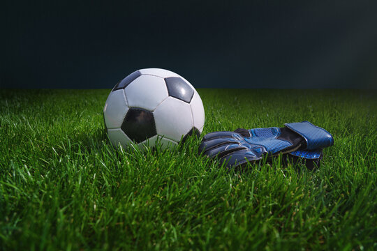 green grass texture with a soccer ball and goalkeeper gloves - well-groomed turf. Banner with copy space.