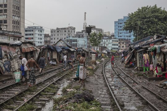 Father with his son walking on the railway tracks, Tejgaon Slum Area, Dhaka, Bangladesh
