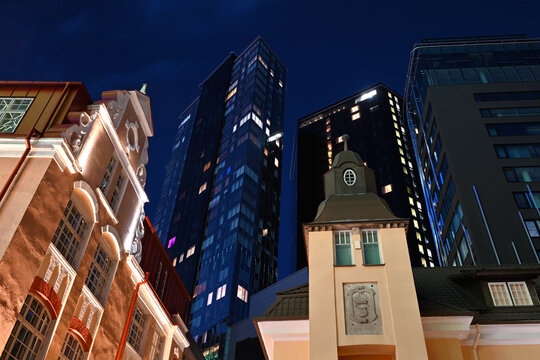 Low angle view of historic and modern buildings in Tallinn at night