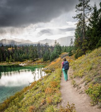 Young hiker at a lake, Fourth Lake, Valley of the Five Lakes, Jasper National Park, back mountains, Alberta, Canada