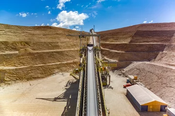Industrial infrastructure and heavy machinery featuring a prominent conveyor belt at a copper mining operation in Chile. © Jose Luis Stephens