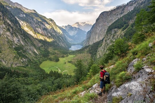 Hiker on the R&ouml;thsteig, view of the Obersee and K&ouml;nigssee, behind Watzmann, Berchtesgaden National Park, Upper Bavaria, Bavaria, Germany