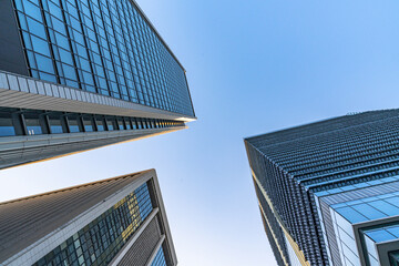 高層ビルを見上げるオフィス街の風景 © Kenta