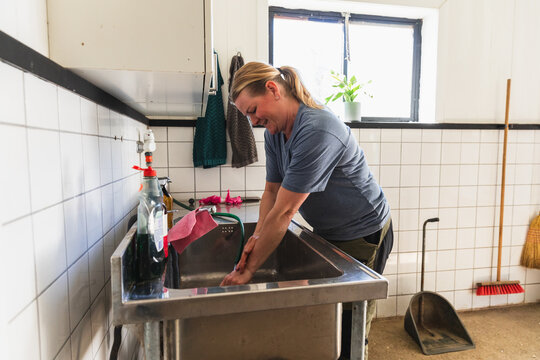 Woman Washing Hands in Farm Utility Room