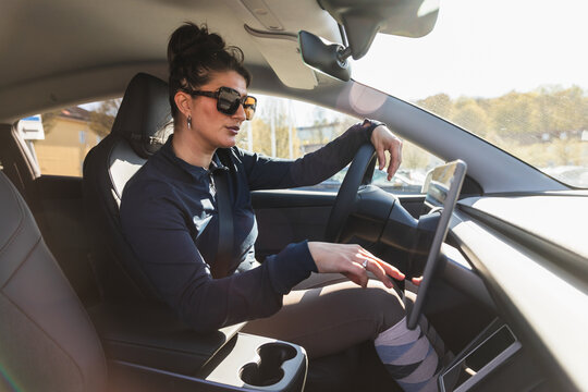 Equestrian Woman Using Touchscreen in Electric Car