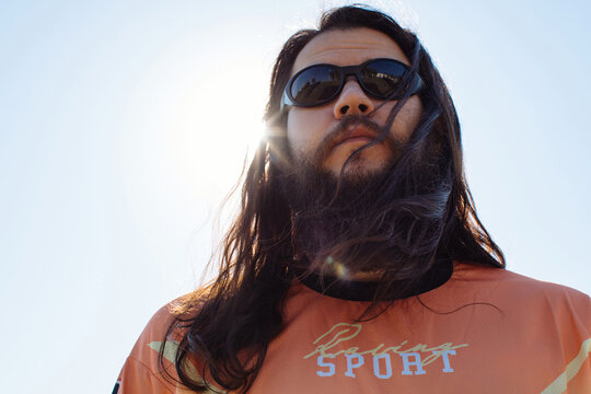 Serious man in sunglasses by the sky