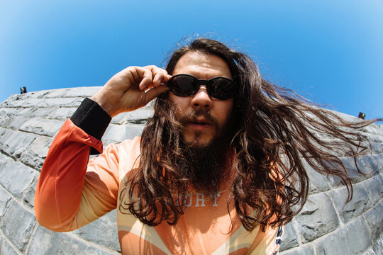 Stylish man with long hair in sunglasses