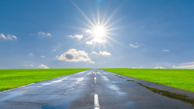 wet asphalt road among green fields under a sparkle sun time lapse scene