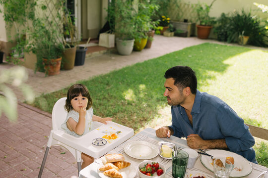 Father and daughter having breakfast in the garden
