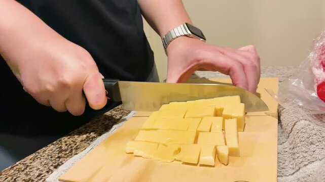 Macro shot of a sharp kitchen knife slicing gouda cheese on a wooden table, traditional Picada Argentina