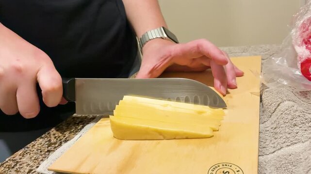 Woman preparing food slicing cheese for a charcuterie board in the kitchen, traditional Picada Argentina