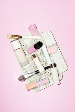 Cute pink makeup products: blush, lip gloss, highlighter, foundation