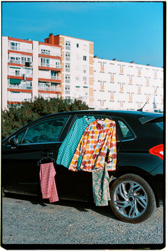 clothes hang from a parked car outdoors, 35mm film