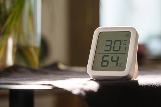 Digital thermometer showing 30 degrees Celsius indoors during a summer heat wave
