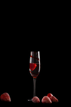 Champagne glass with strawberry on black background