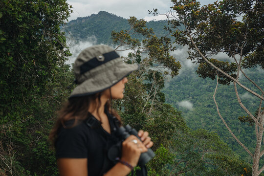 Woman with binocular in mountain cloud forest