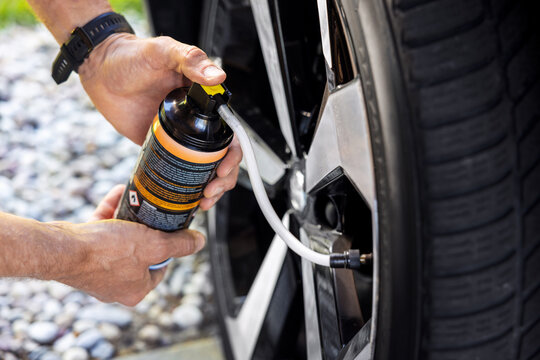 spraying aerosol seal to fix flat car tire